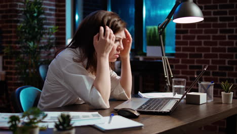 Worker-exasperated,-putting-head-in-head,-frustrated-by-too-much-work-in-office