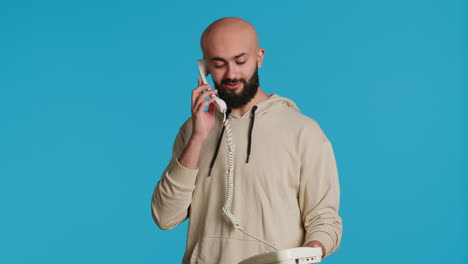 Muslim-adult-taking-call-on-a-landline-phone-in-studio