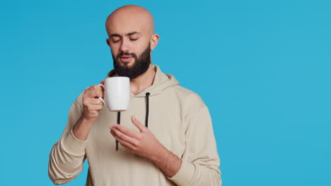 Muslim-person-enjoying-fresh-caffeine-aroma-in-studio