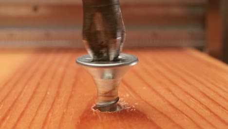 Close-up-is-an-electric-drill-the-screws-a-self-tapping-screw-into-a-wooden-bar.