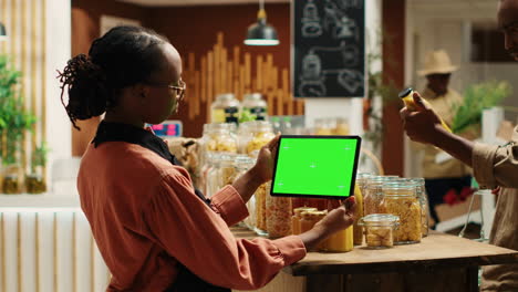 African-american-woman-uses-greenscreen-on-tablet-in-supermarket