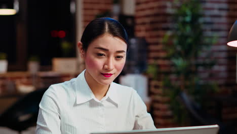 Zoom-in-on-smiling-businesswoman-inputting-data-on-laptop