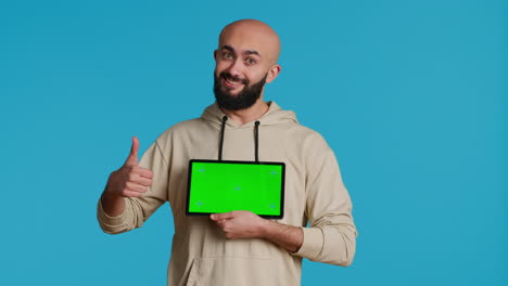 Arab-guy-holding-device-with-greenscreen-blank-display
