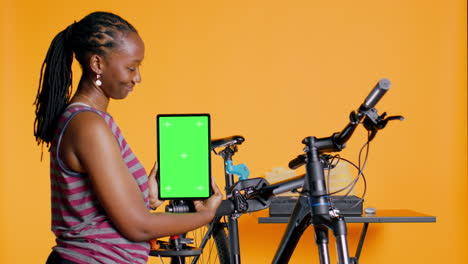 Mechaniker-Wirbt-Für-Fahrradreparaturservice-Mit-Mockup-Tablet,-Studiohintergrund