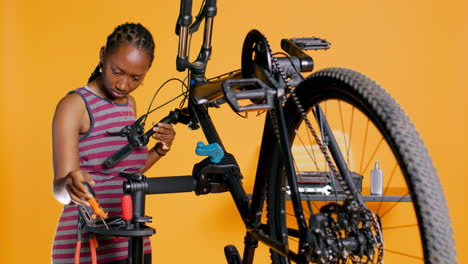 Expert-uses-screwdriver-to-tighten-brake-levers-on-bicycle,-examining-components