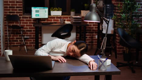 Tired-employee-asleep-on-computer-desk-chair-suddenly-waking-up