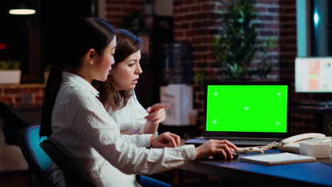 Manager-and-worker-comparing-business-revenue-numbers-on-chroma-key-laptop