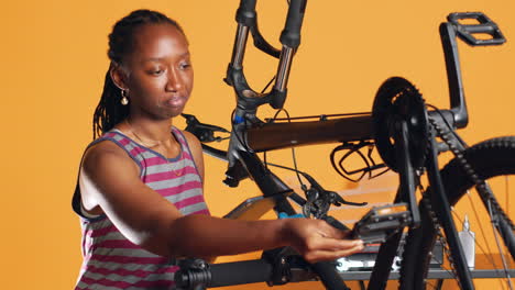 Mujer-Siguiendo-Tutoriales-En-Línea-En-Una-Tableta-Y-Aprendiendo-A-Reparar-Su-Bicicleta-Dañada.