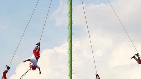Papantla-flyers-tied-by-the-ankles-with-a-rope-spining-around-a-metallic-pole