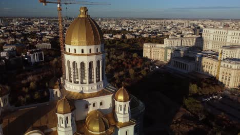 Close-up-parallax-view-of-the-construction-site-of-the-Cathedral-of-the-Salvation-of-the-Nation,-Bucharest,-golden-hour