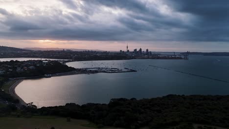 Hyperlapse-Luftaufnahme-Der-Skyline-Von-Auckland-Während-Des-Sonnenuntergangs-Mit-Dem-Hafen-Im-Vordergrund