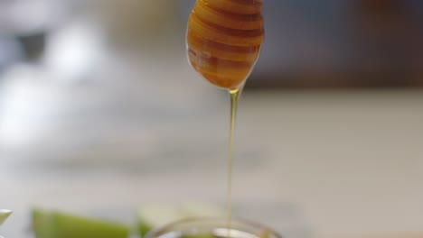 Golden-Honey-Dripping-from-Wand-Over-Glass-Jar