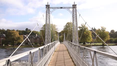 modern-pedestrian-bridge-crossing-a-river-in-Inverness,-Scotland-in-the-Highlands