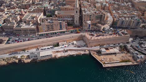 Aerial-Tilt-Reveal-of-St-Paul's-Cathedral-Dome-in-Valletta-Skyline,-Malta