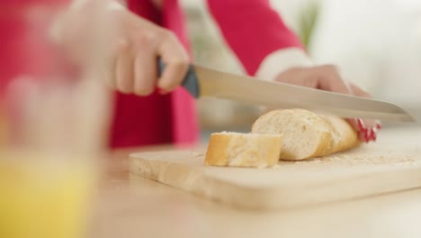 Woman-in-the-red-clothes-Slicing-A-Loaf-Of-White-Bread