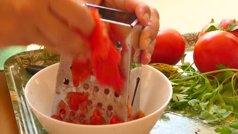 Detail-of-female-hand-grated-tomato-for-preparation-of-typical-Valencian-paella