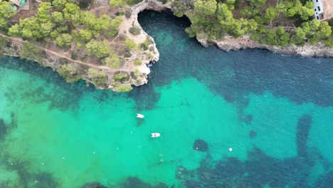 Birds-eye-view-of-a-turquoise-patch-of-sea-on-the-coast-of-East-Mallorca,-aerial