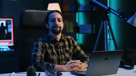 Portrait-of-happy-man-sitting-at-home-office-desk,-solving-tasks-on-laptop