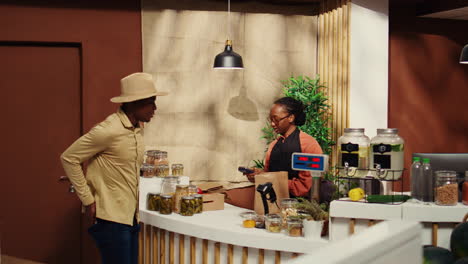 African-american-man-paying-for-eco-friendly-food-at-checkout