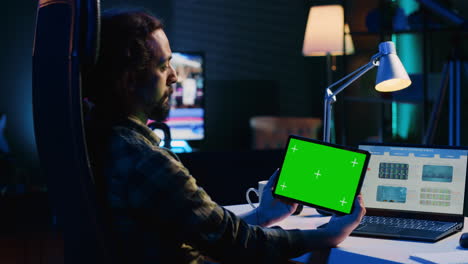 Freelancer-holding-green-screen-tablet,-analyzing-statistical-charts