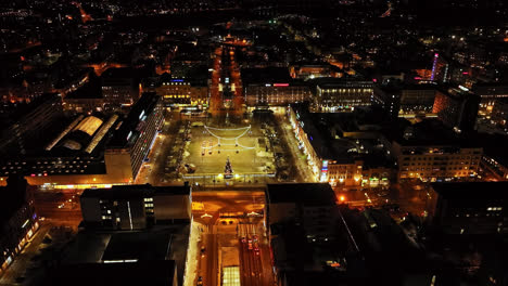 Aerial-view-tilting-toward-the-illuminated-market-square-of-Vaasa,-winter-in-Finland