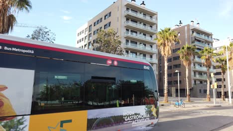 Eine-Bus-Straßenbahn-Fährt-Bei-Warmem-Tageslicht-Durch-Die-Straßen-Von-El-Poblenou,-Barcelona