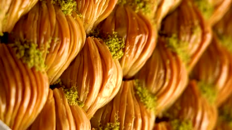 A-tray-of-pieces-of-Turkish-baklava-sweets-with-pistachios-,-slow-motion-video,-vertical-video