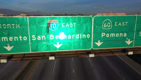 Aerial-view-rising-in-front-of-freeway-signs-at-the-closed-Interstate-10-in-LA,-USA