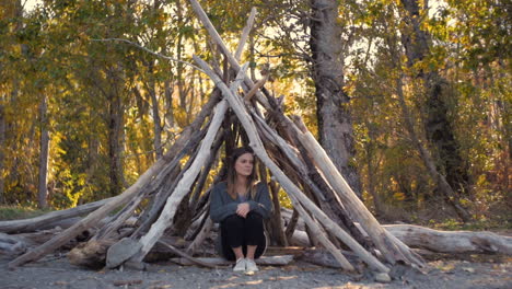 Young-girl-contemplative-in-the-woods-under-stick-fort