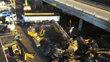 Aerial-view-following-a-excavator-lifting-fire-damage-to-a-truck-at-Interstate-10-in-LA