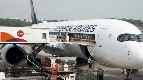 Worker-Seen-Pushing-Plane-Trolly-Cart-From-Airport-Catering-Truck-Servicing-Singapore-Airlines-A350-900-At-Changi-Airport,-Singapore