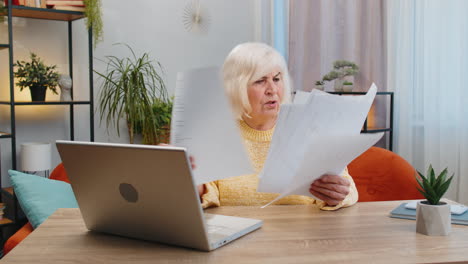 Gestresste-ältere-Frau,-Die-Unbezahlte-Bankschulden-Betrachtet-Und-Papierkram-Erledigt,-Budgetplanung-Wirft-Rechnungen