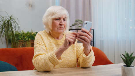 Ältere-Großmutter-Benutzt-Smartphone,-überrascht-Von-Schlechten-Nachrichten,-Vermögensverlust,-Scheitern,-Lotterieergebnissen