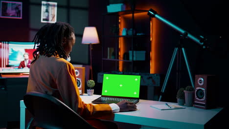 African-american-young-woman-looks-at-laptop-with-greenscreen