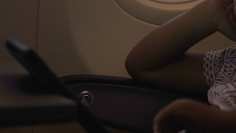 Vista-De-Cerca-De-Un-Niño-Pequeño-Jugando-Con-El-Panel-Táctil-En-La-Mesa-En-Un-Avión