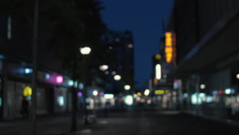 Defocused-shot-of-night-street-with-illuminated-banners