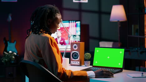 African-american-young-woman-looks-at-laptop-with-greenscreen