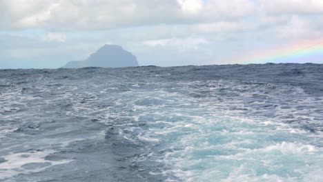 Wavy-ocean-and-distant-island-view-from-the-ship