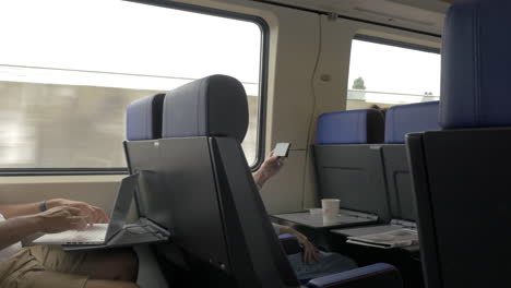 Men-using-cellphone-and-laptop-in-commuter-train