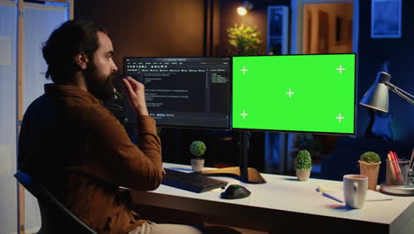 Programmer-typing-complex-code-on-green-screen-computer-in-neon-lit-home-office