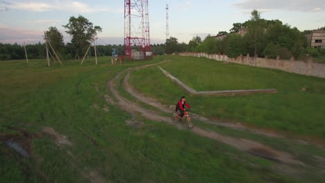 Aerial-view-of-boy-riding-bike-in-the-countryside