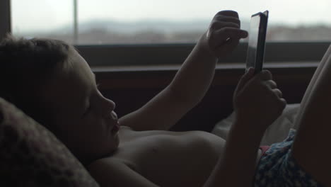 Niño-Usando-Tableta-Digital-En-La-Cama