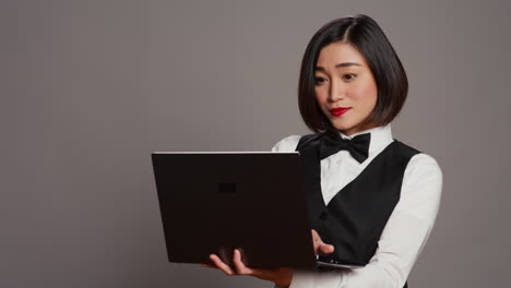 Asiatischer-Hotelangestellter-Registriert-Personen-Mit-Laptop-An-Der-Rezeption