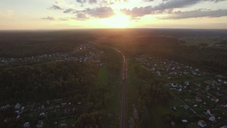 Flying-over-countryside-and-freight-train-at-sunset-Russia