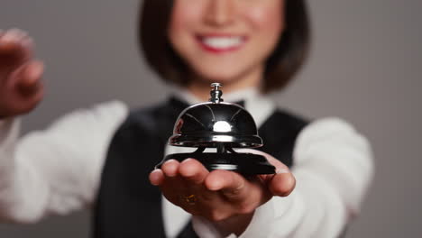Receptionist-posing-with-service-bell-and-ringing-it-on-camera