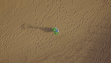 Woman-on-the-sand-with-Brazilian-flag-aerial-shot