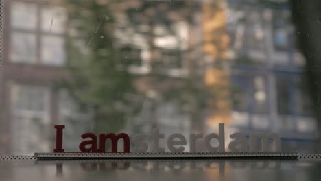 Window-of-moving-tram-with-I-amsterdam-slogan