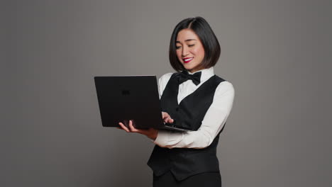 Asiatischer-Hotelangestellter-Registriert-Personen-Mit-Laptop-An-Der-Rezeption