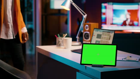 African-american-pupil-looks-at-greenscreen-display-on-tablet