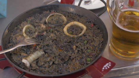 Woman-eating-black-paella-with-seafood
